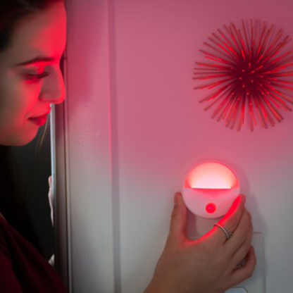 Woman placing the TrueLight Portable Nightlight on the wall