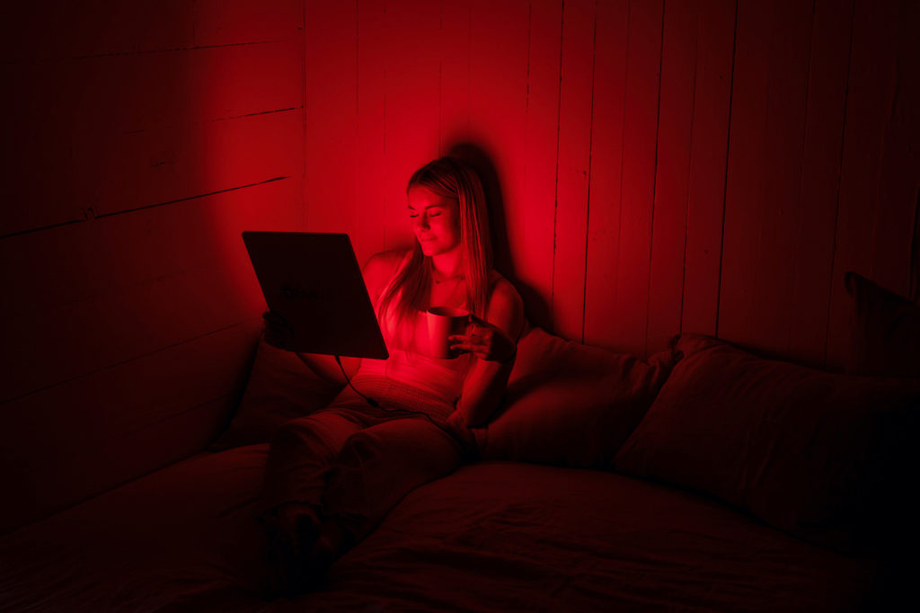 Woman using the TrueLight® Energy Square 2.4 for red light therapy